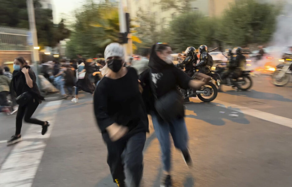 Demonstranter springer ifrån kravallpolisen i centrala Tehran 19 september 2022, tre dagar efter Mahsa Aminis död.