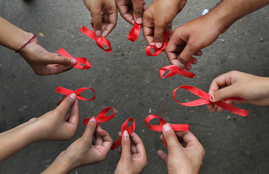 Aktivister med röda band, ,den internationella symbolen för medvetenhet om hiv och aids.