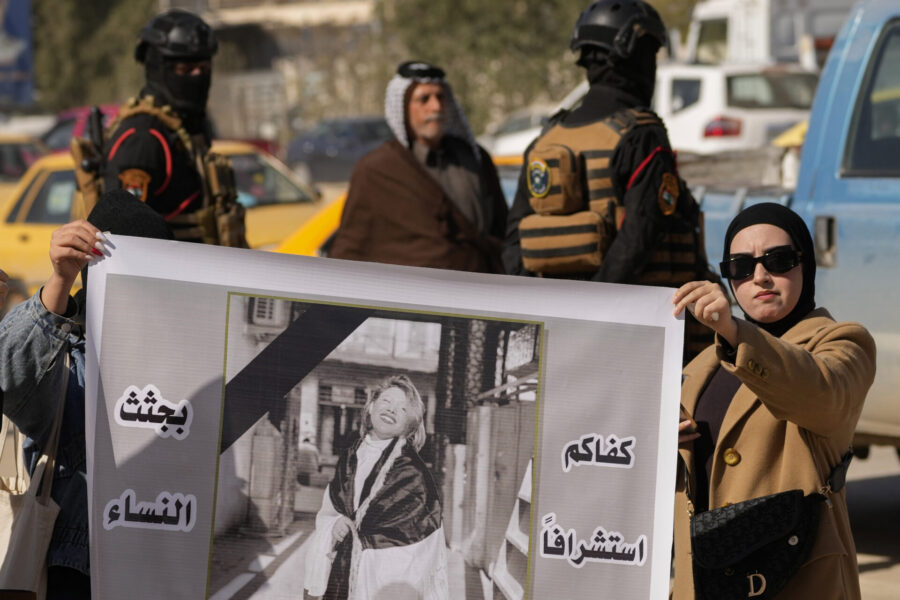 Demonstranter bär en affisch med en bild på Tiba Ali, en YouTube-stjärna som nyligen dödades av sin far, i Diwaniya, Irak, söndagen den 5 februari 2023.