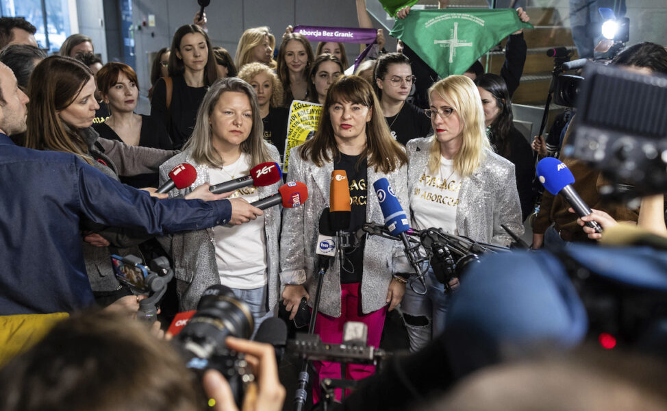 Kvinnorättsaktivisten, Justyna Wydrzyńska (i mitten) efter att hon dömts i domstol tisdag 14 mars 2023 för att ha hjälpt en kvinna att få tillgång till säker abort.
