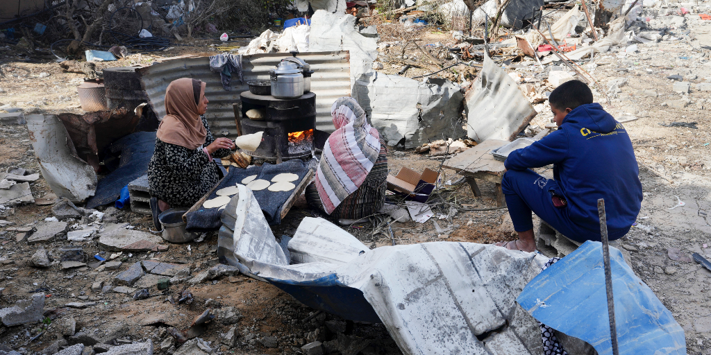 Palestinska kvinnor bakar bröd intill sitt hem som har förstörts av en israelisk attack i byn Khuza'a öster omo Khan Younisi östra Gazaremsan i slutet av november.
