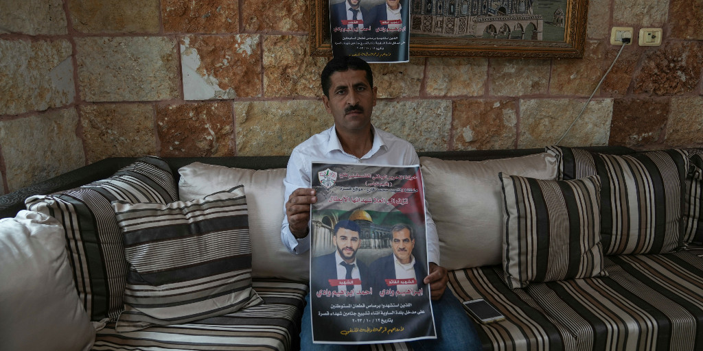 Abdelazim Wadi hållerupp en affisch med brodern Ibrahim Wadi och brorsonen  Ahmed Wadi som bådade dödades av israeliska bosättare under en begravning den 12 oktober i år i den palestinska byn Qusra på ockuperade Västbanken.