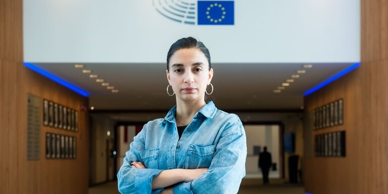 Porträttbild på Evin Incir framför en EU-flagga