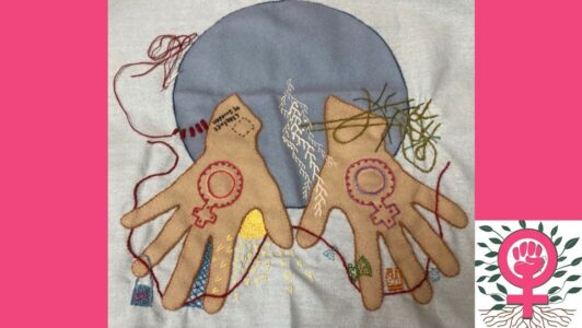 Ett broderi med två händer som kommer ut från en blå cirkel