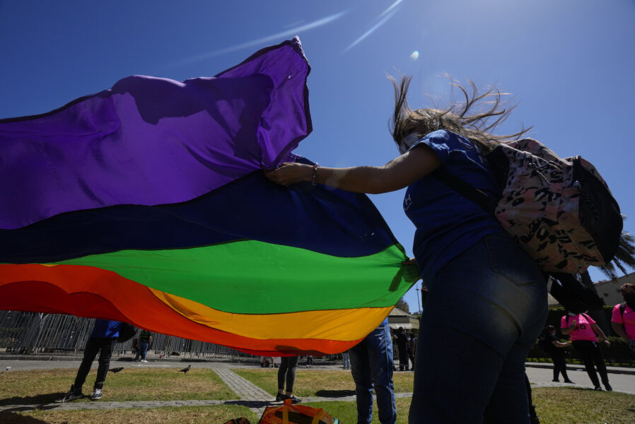 hbtqi-flagga hålls ut i vinden av en person