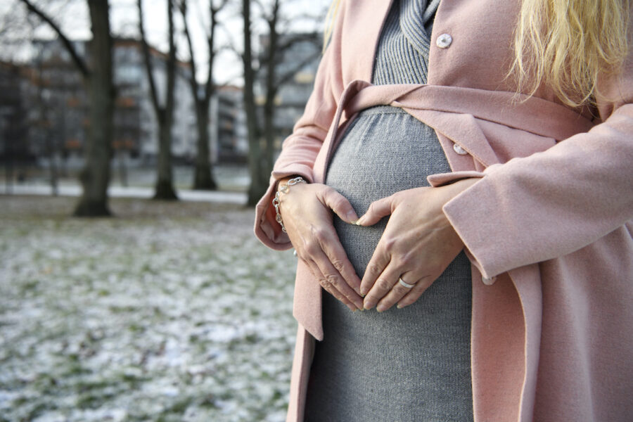 Bild på en gravid kvinnas mage, tagen utomhus på vintern