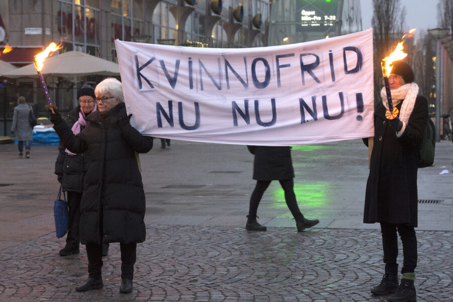 Två kvinnor håller i en banderoll där det står Kvinnofrid Nu Nu Nu