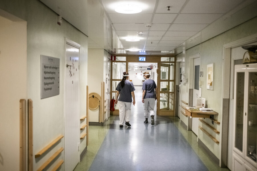 sjukhuskorridor med två sjukvårdsanställda i bakgrunden