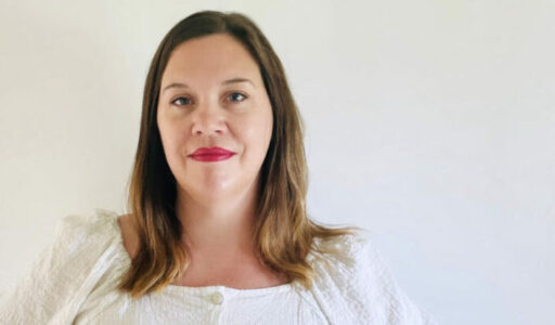 Lina Stenberg i vit blus och rött läppstift