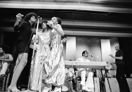 Stevie Wonder sings and plays electric piano as he is accompanied by three female singers from his group on the stage of the Apollo Theater in the Harlem neighborhood of New York. N.Y. Columbia University and the Apollo Theater Foundation on Thursday, Oct. 23, 2008 announced a joint project to create an oral history of the famed Harlem theater that launched the careers of Stevie Wonder, Ella Fitzgerald, Sarah Vaughan, Smokey Robinson and other music legends. (AP Photo/Jim Wells,