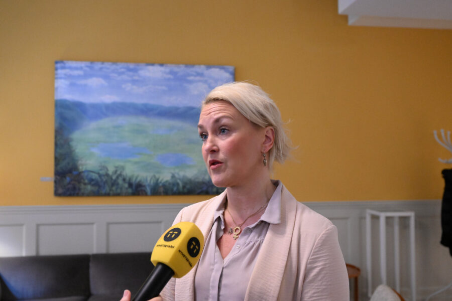 Olga Persson svarar på frågor med en mikrofon i förgrunden.