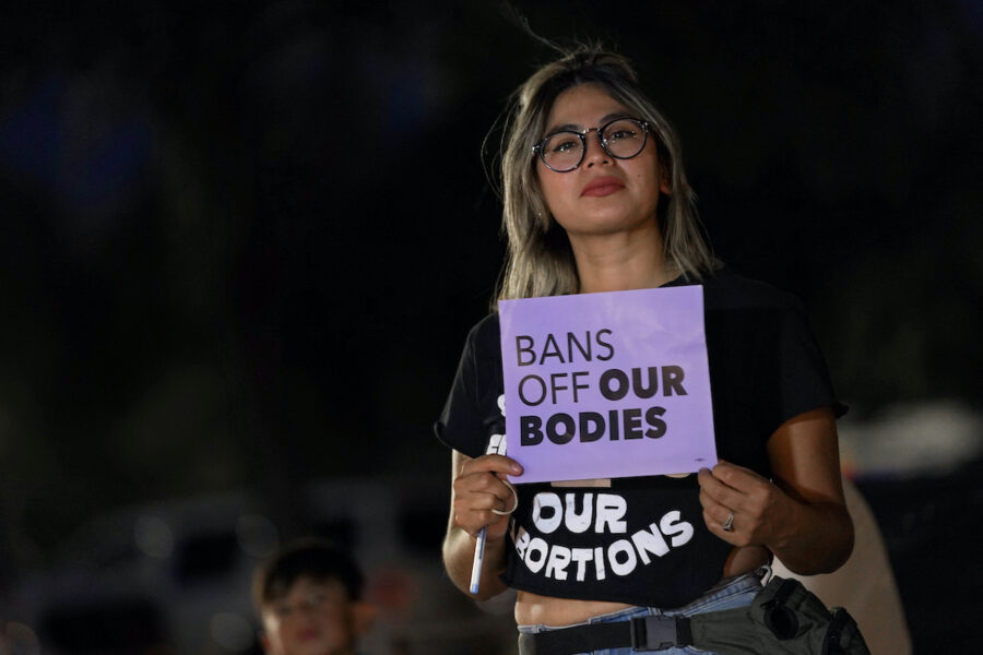 Kvinna med skylt I protest mot inskränkt aborträtt