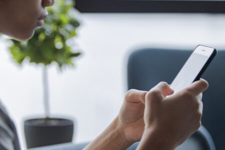 ung person håller en mobil i händerna