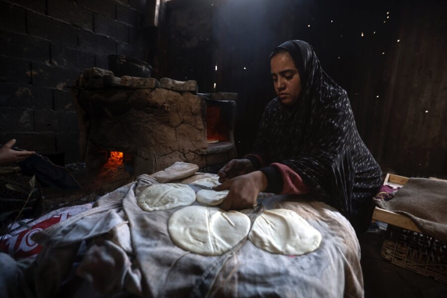Kvinna bakar bröd i tält.