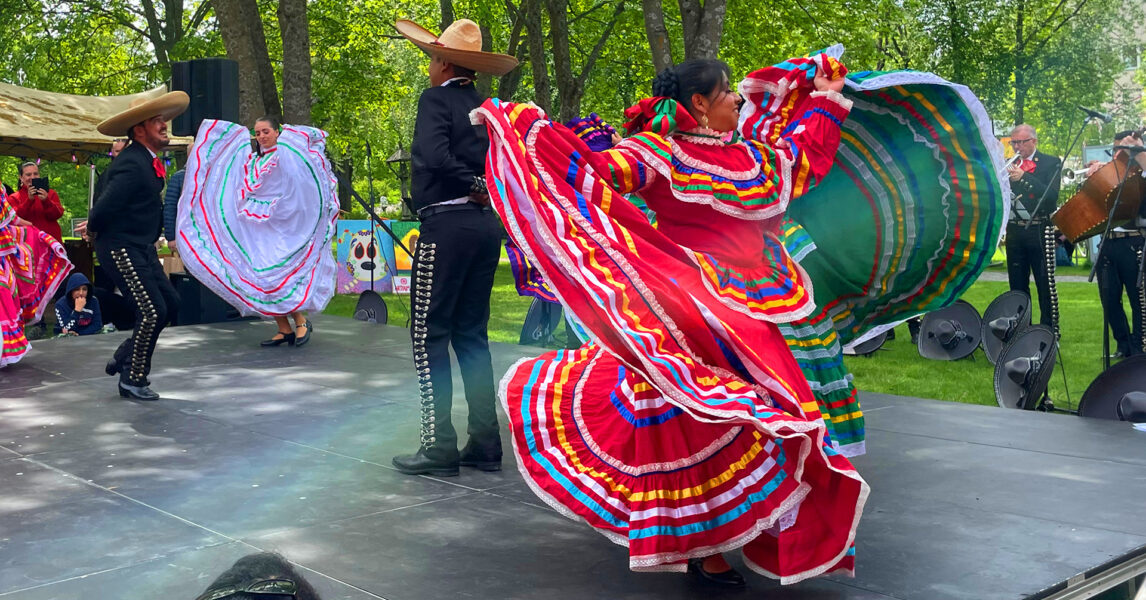 En kvinna dansar iklädd en rosa mexikansk klänning