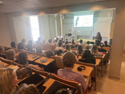 man ser ryggarna på ungdomar i en föreläsningssal.