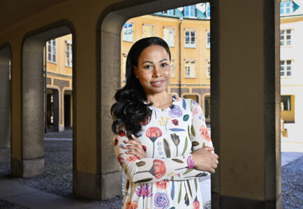 Alice Bah Kuhnke i vit klänning med stora sommarblommor