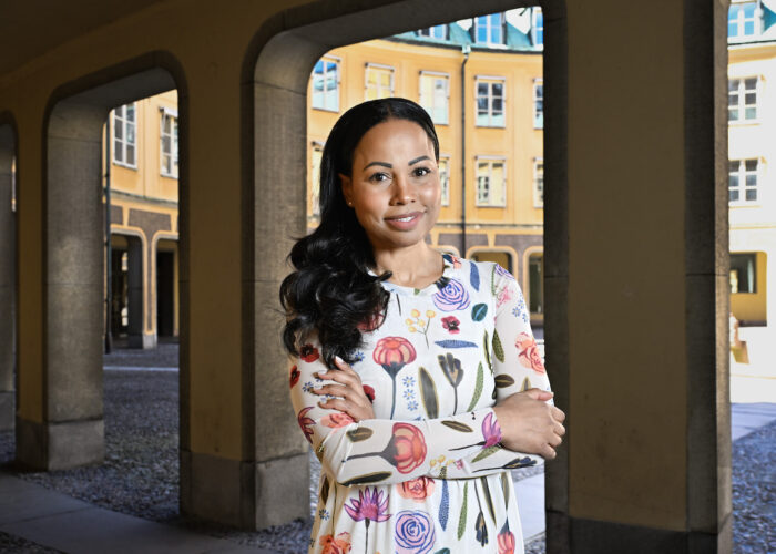Alice Bah Kuhnke i vit klänning med stora sommarblommor