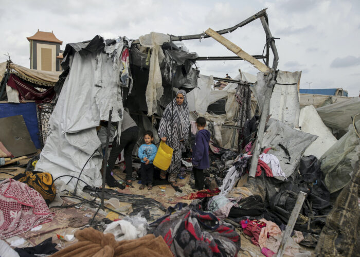 En kvinna och två barn bland brända tältrester i krigets Gaza