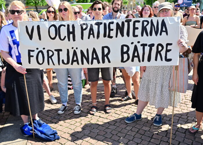 En grupp demonstranter håller i en banderoll där det står Vi och patienterna förtjänar bättre