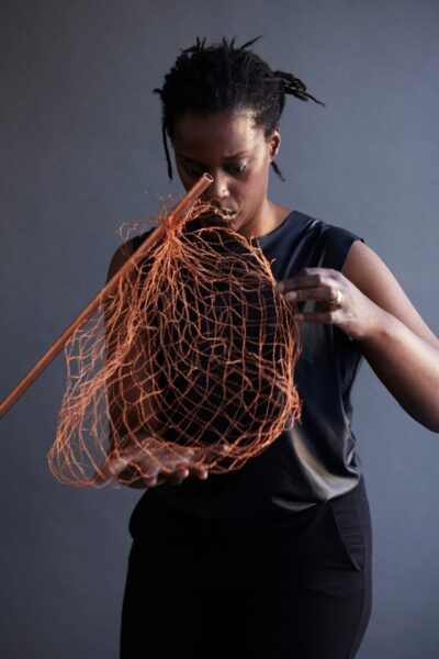 kvinna håller i ett konstföremål som ser ut som nät