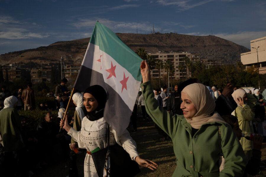 Kvinnor håller i den syriska oppositionens flagga.