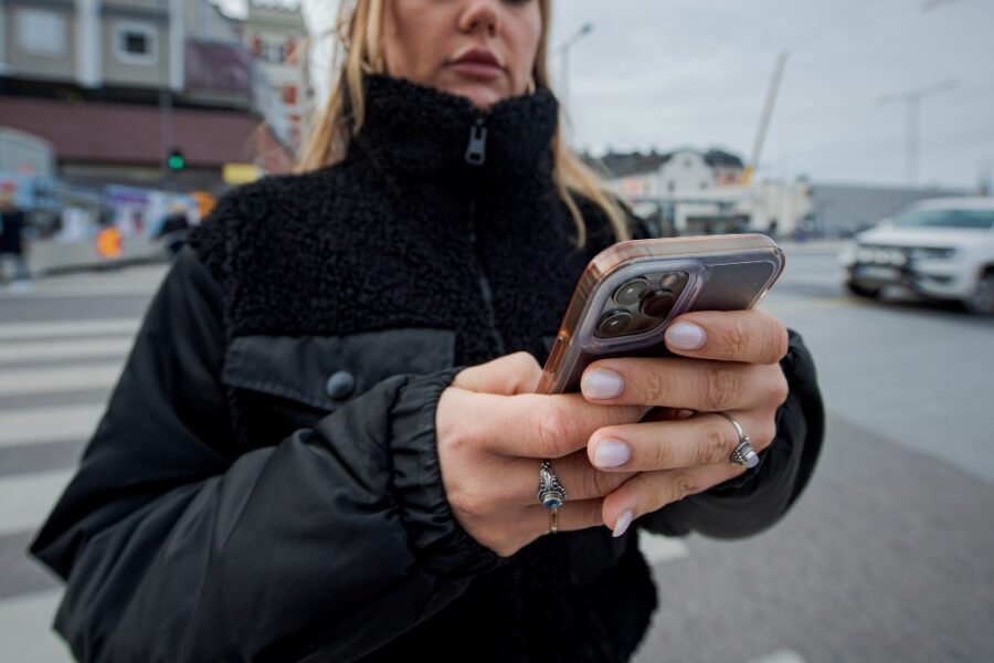 Ung kvinna med mobil i handen.