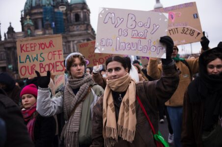 Kvinnor håller upp plakat.