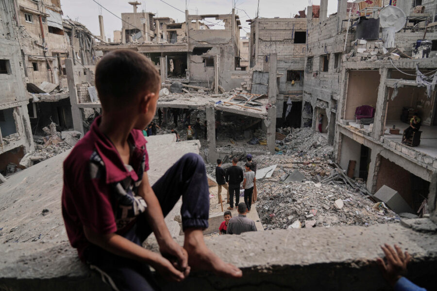 Palestinsk pojke blickar ut över rasmassor i Gaza.