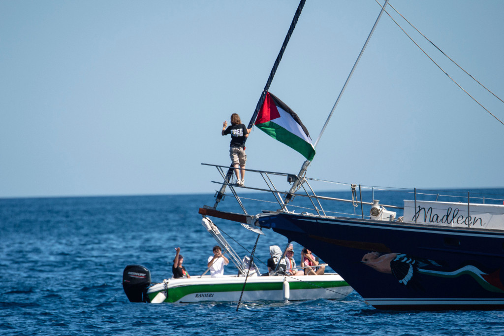 Greta Thunberg i fören på fartyget Madleen med en Palestinaflagga.