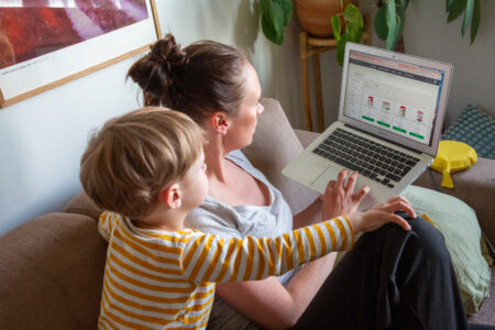 Kvinna och barn tittar på datorskärm.