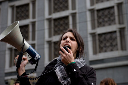 Kvinna med Palestinasjal och megafon.