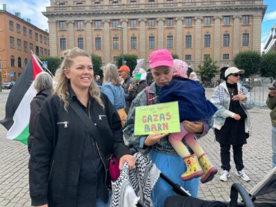 Två mammor manifesterar med skylt.