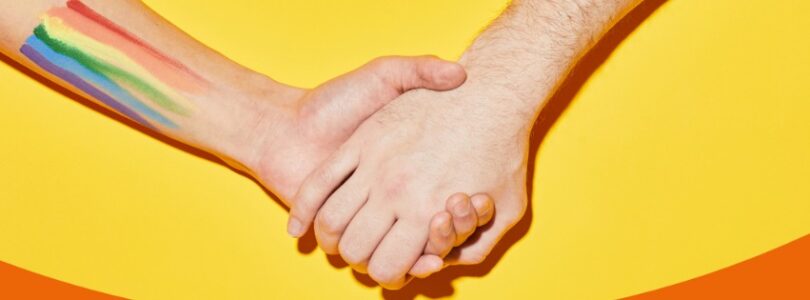 Hand i hand mot gul bakgrund.