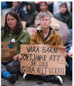 Kvinnor i sittande manifestation med plakat.