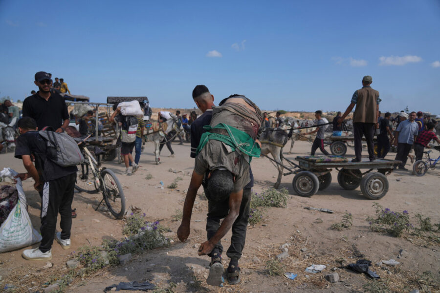En palestinsk man bär på kroppen av en man som dödades när han försökte få tag på mat.