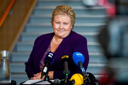 Erna Solberg med flera mikrofoner framför sig.