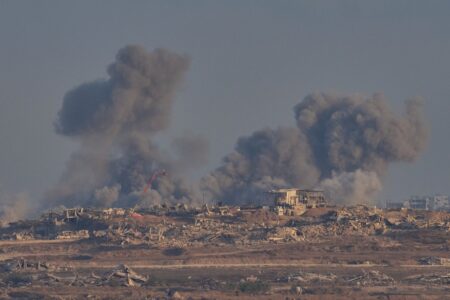 Bombardemang av Gaza, demolerade hus och mörk rök stiger mot skyn.
