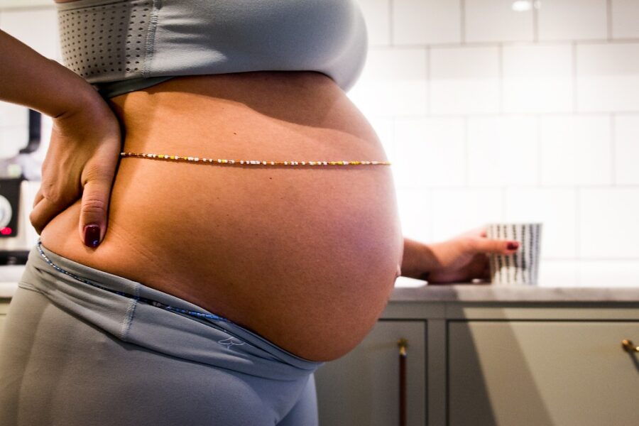 Gravid kvinnas mage i profil.