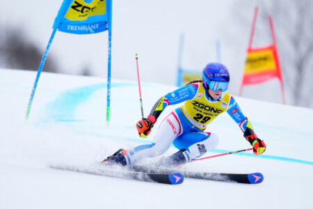 Kvinna åker storslalom i blå kläder och hjälm.