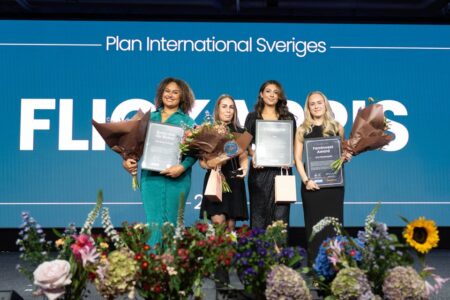 Vanessa Kamga, Tina Kara och Faten Elamiri från Tris och Linn Rosenqvist, de tre vinnarna av Flickapriset 2025 på scen med blombuketter.
