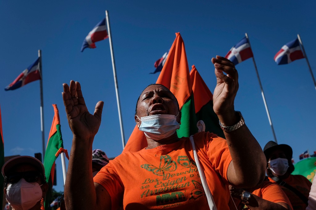 Demonstranter i Dominikanska republiken i orange kläder.