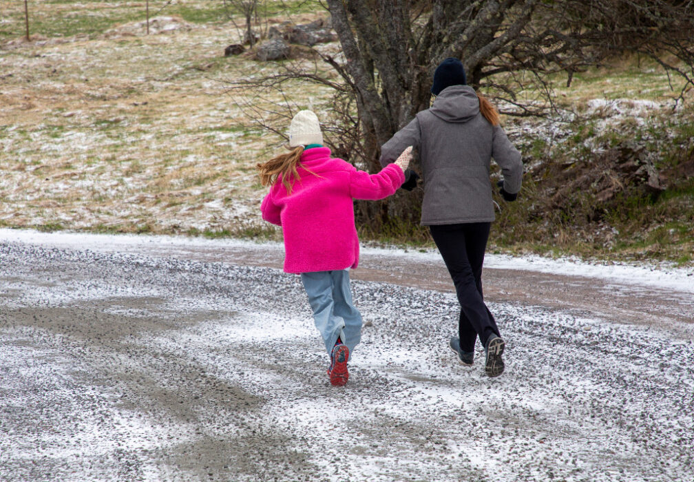 Ryggtavlor på barn och en mamma springer i höst/vintermiljö.