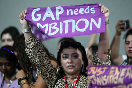 Kvinna håller upp en liten lila banderoll.