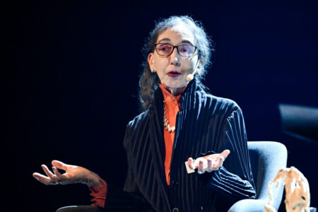 Joyce Carol Oates sitter och slår ut armarna i en gest.